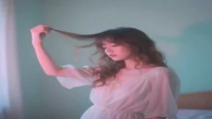 A woman holding her hair and showing visible hair fall, highlighting hair thinning and scalp issues.