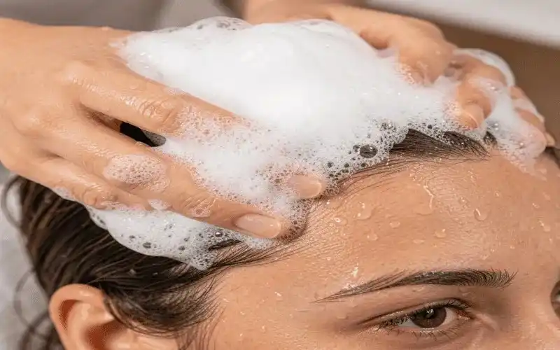 Hands massaging the scalp while using the best shampoo for hair loss women Walmart.