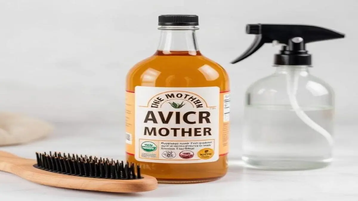 A bottle of raw organic apple cider vinegar with "The Mother," a clear spray bottle for dilution, and a wooden scalp massage brush, representing the natural apple cider vinegar rinse for scalp buildup treatment and ingredients.